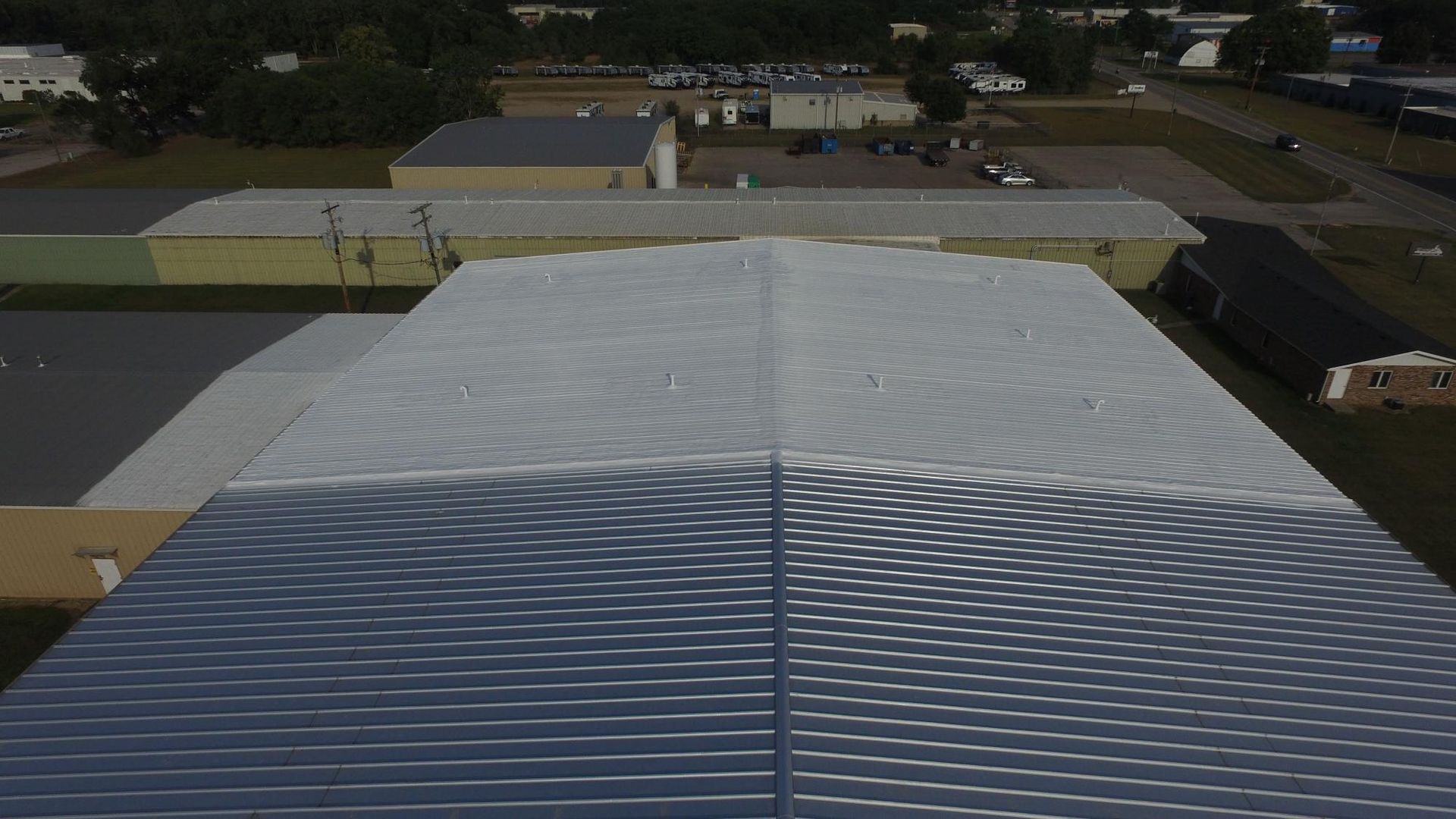 An aerial view of a large building with a white roof.