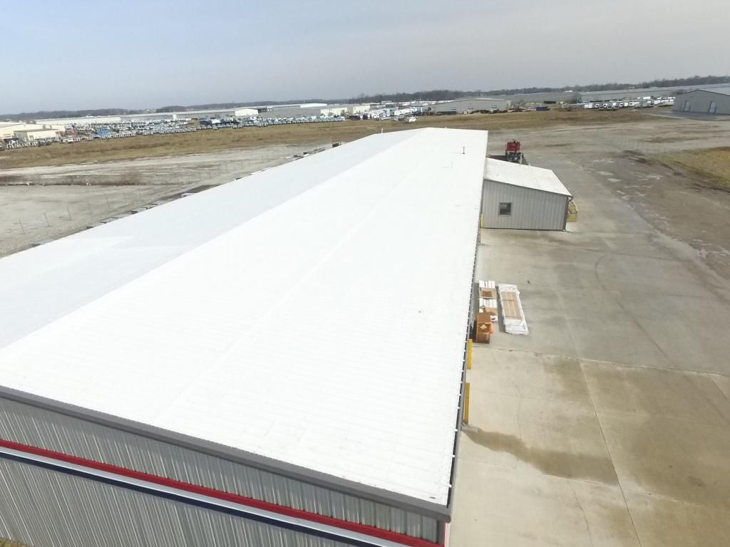 An aerial view of a large building with a white roof.