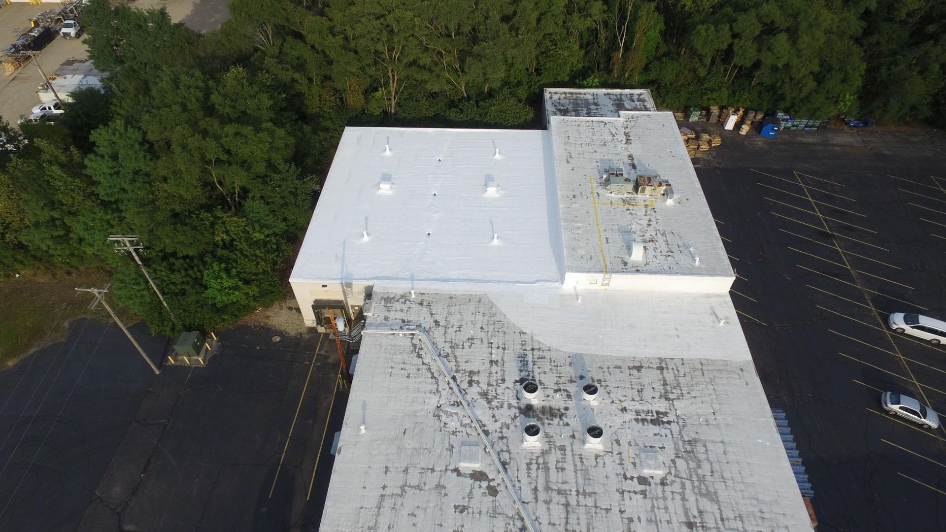 An aerial view of a large building with a white roof.