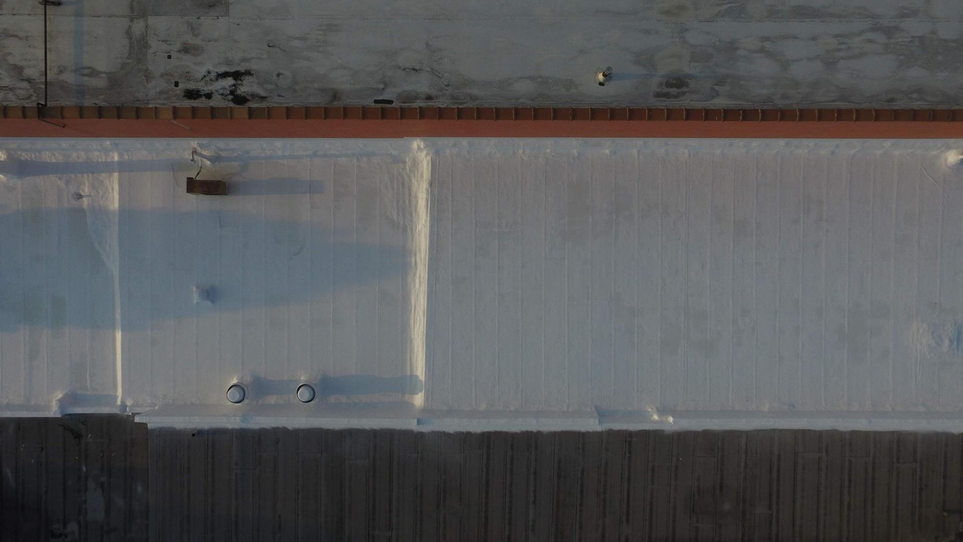 An aerial view of a white roof of a building.