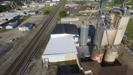 An aerial view of a factory next to a train track.