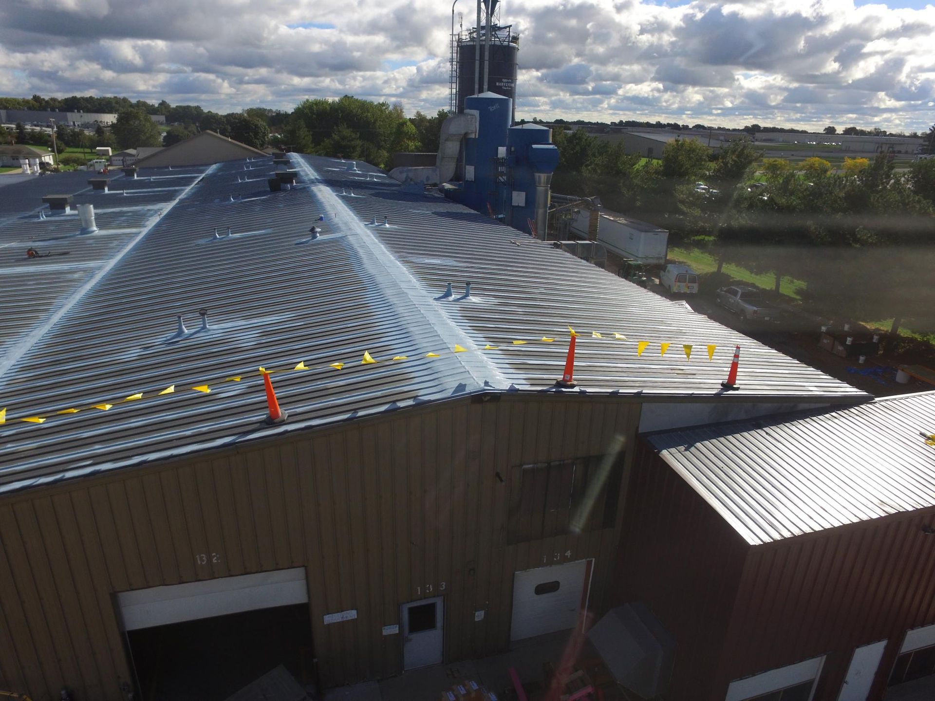 An aerial view of a building with a roof that is being painted