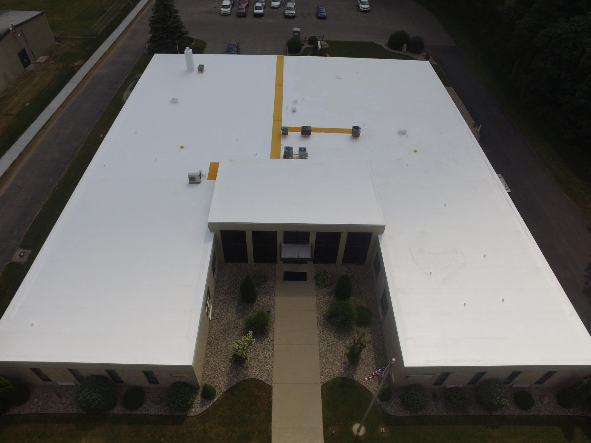 An aerial view of a large building with a white roof.