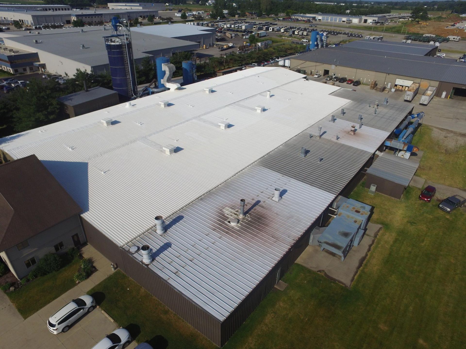 An aerial view of a large building with a white roof