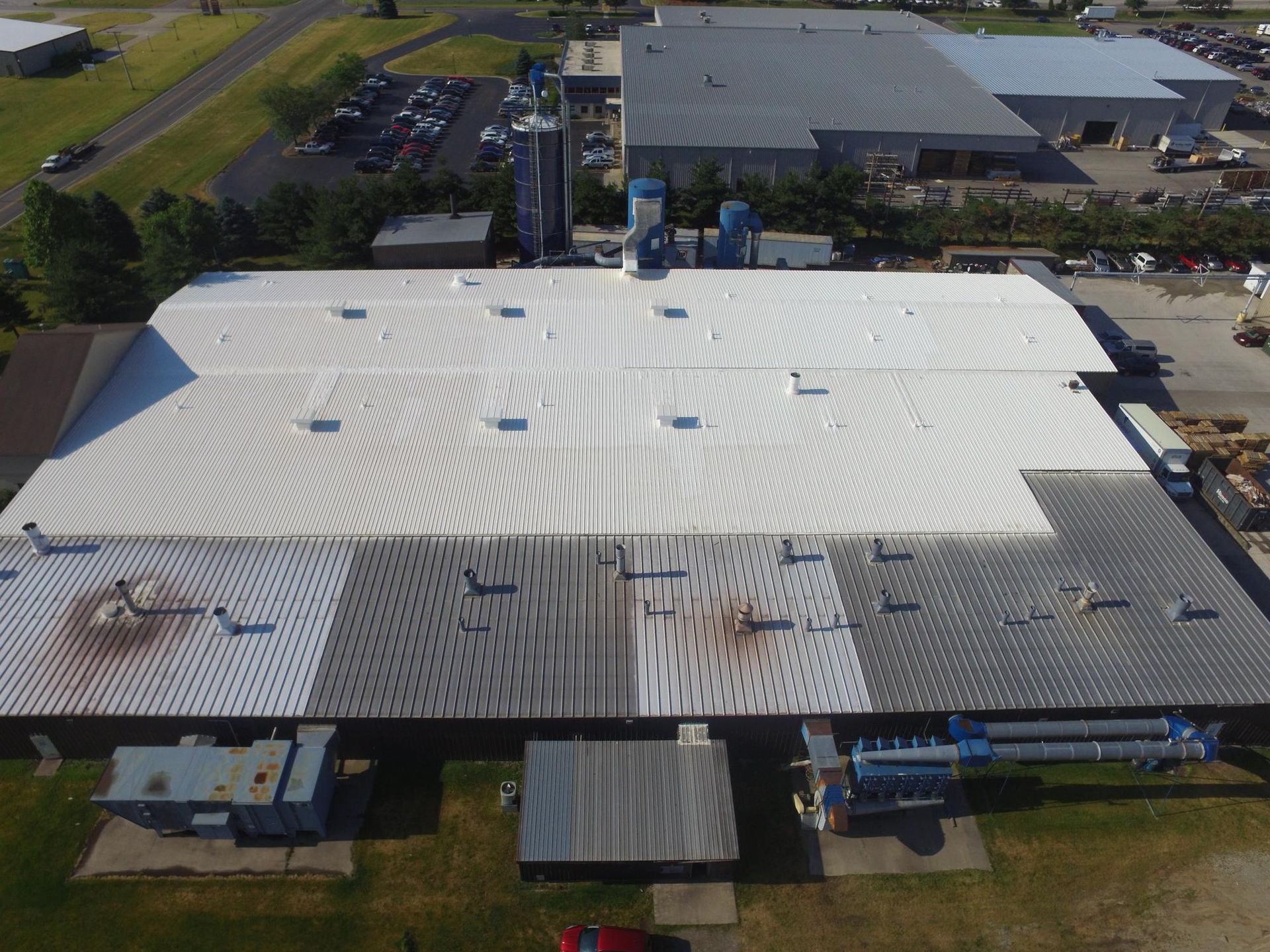 An aerial view of a large building with a white roof