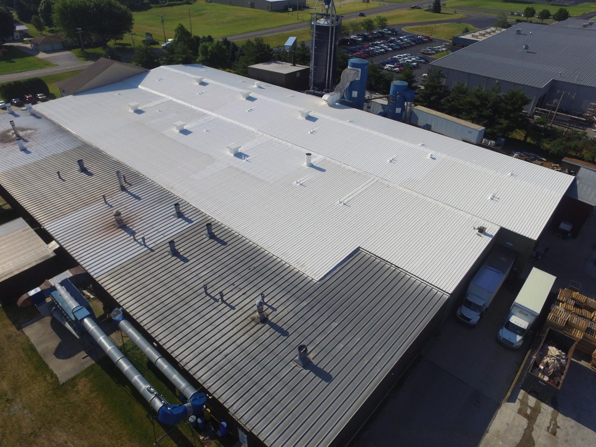 An aerial view of a large building with a white roof