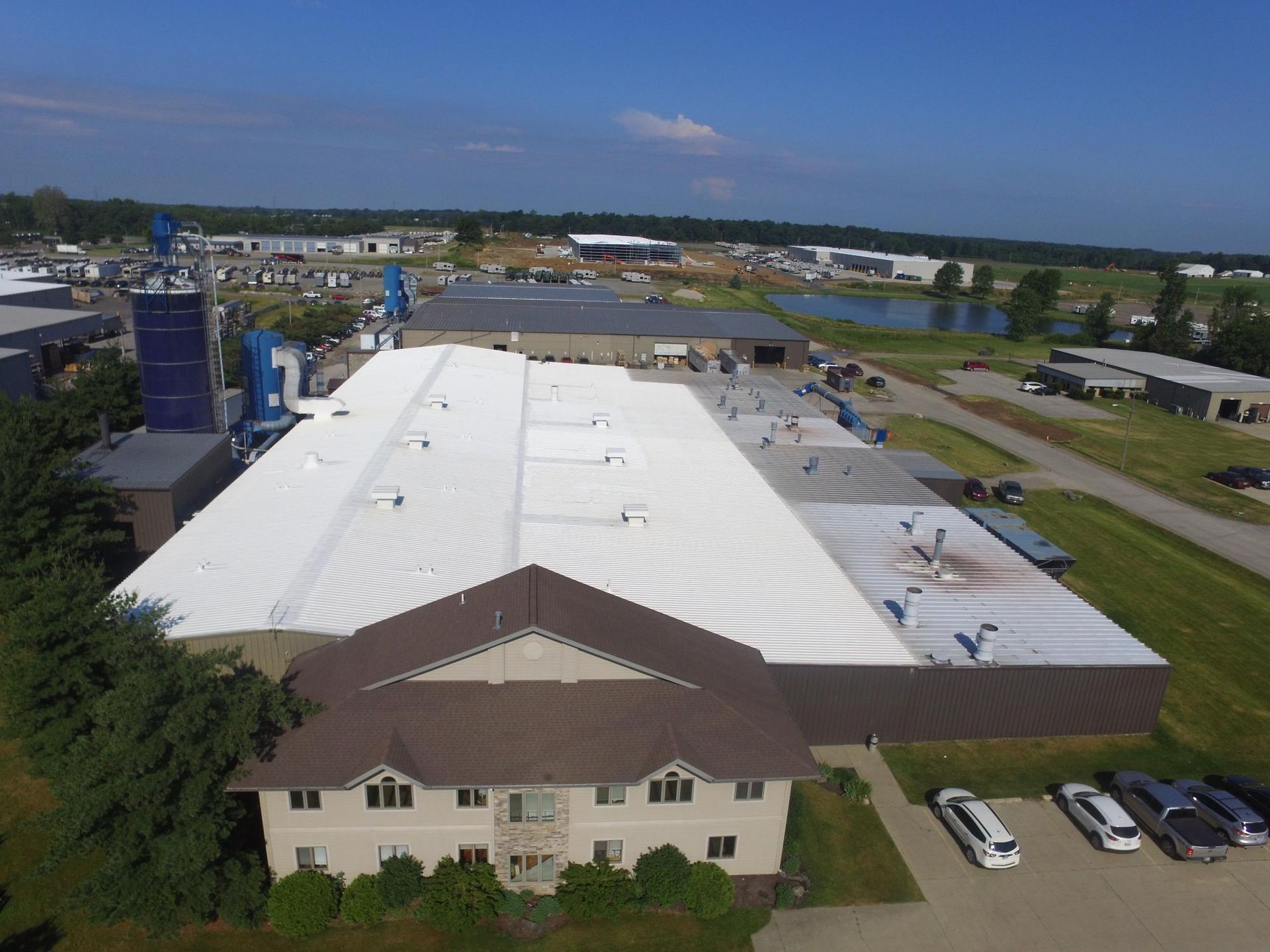An aerial view of a large building with a white roof