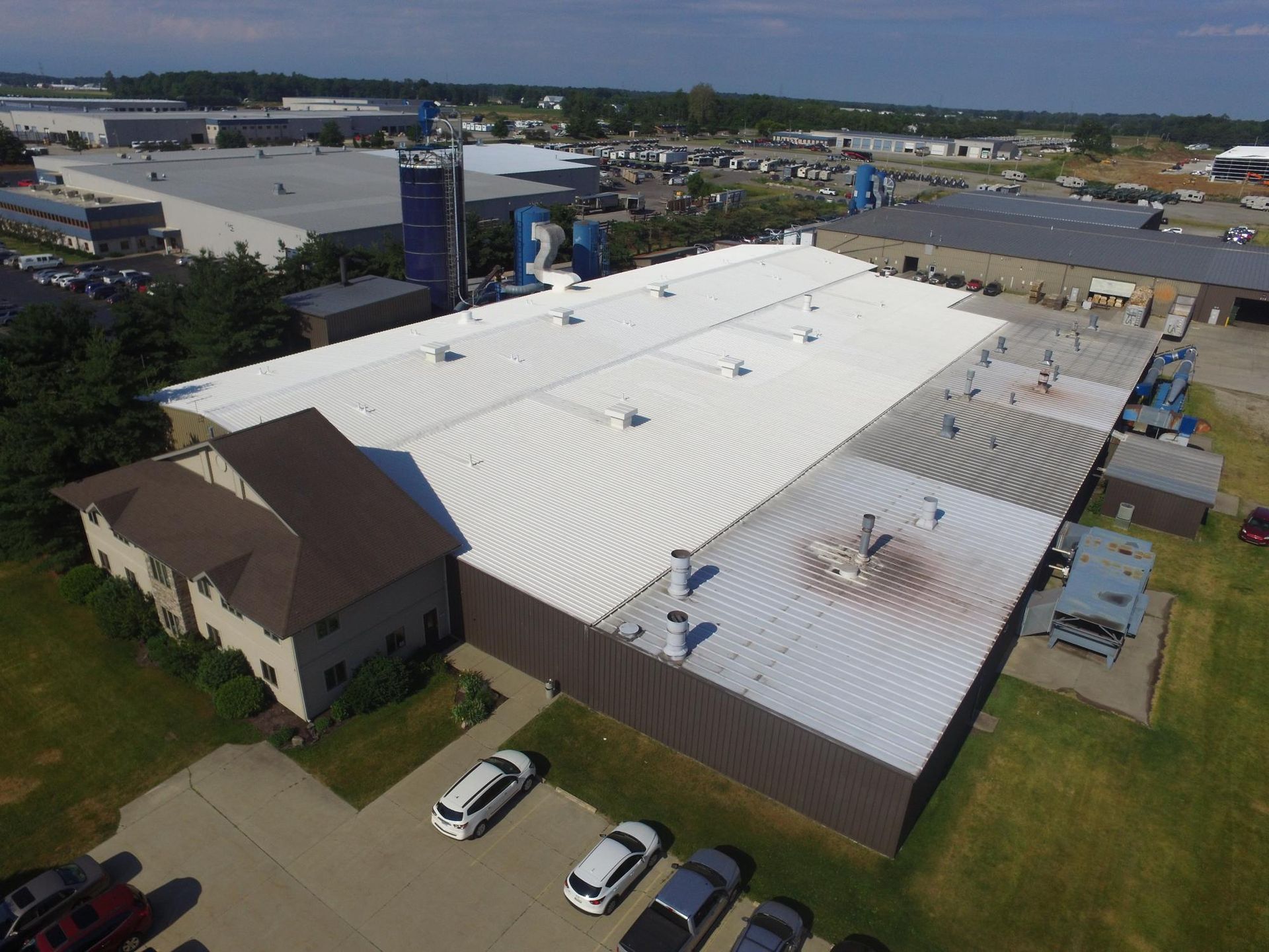 An aerial view of a large building with a white roof
