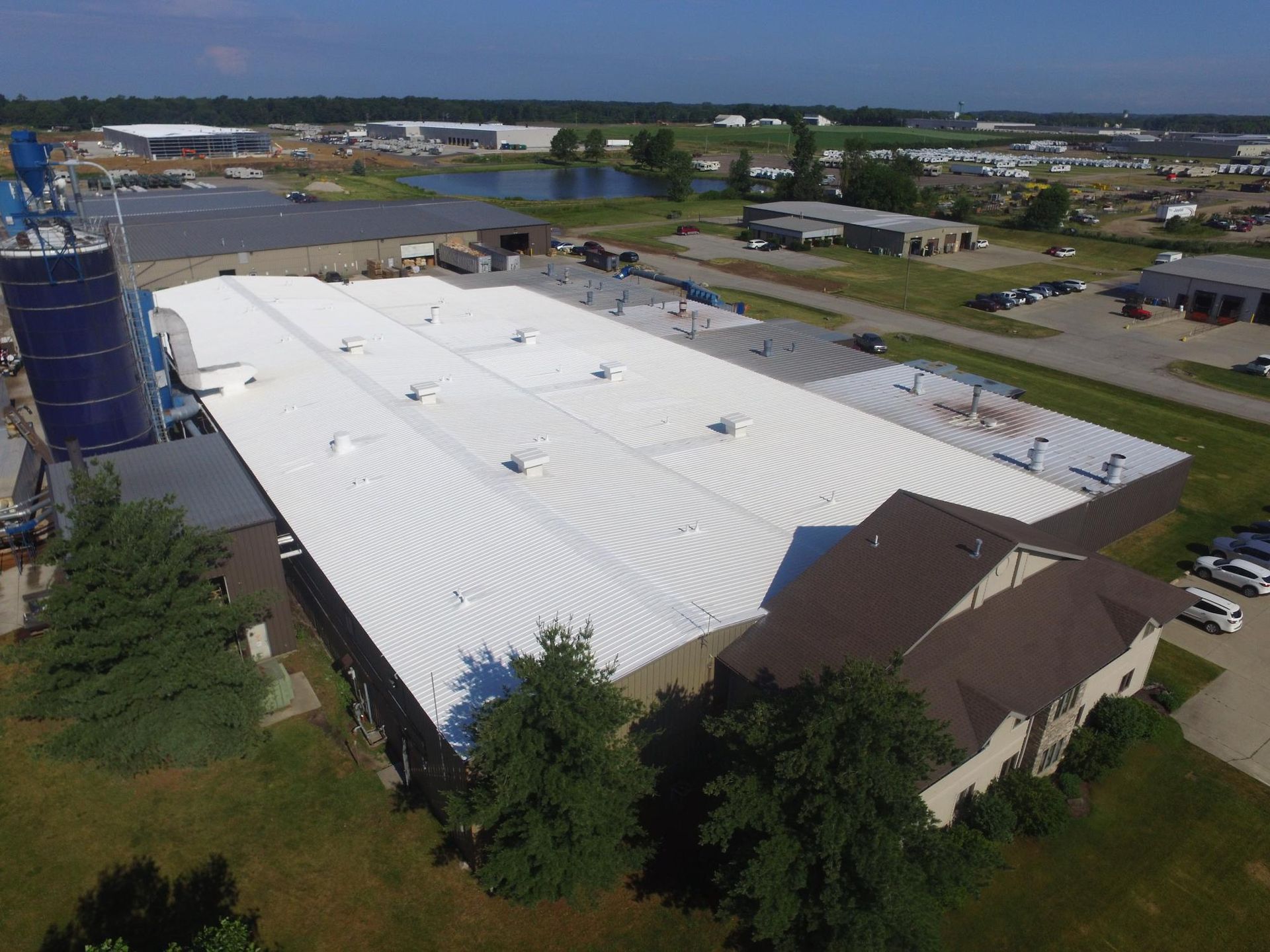 An aerial view of a large building with a white roof