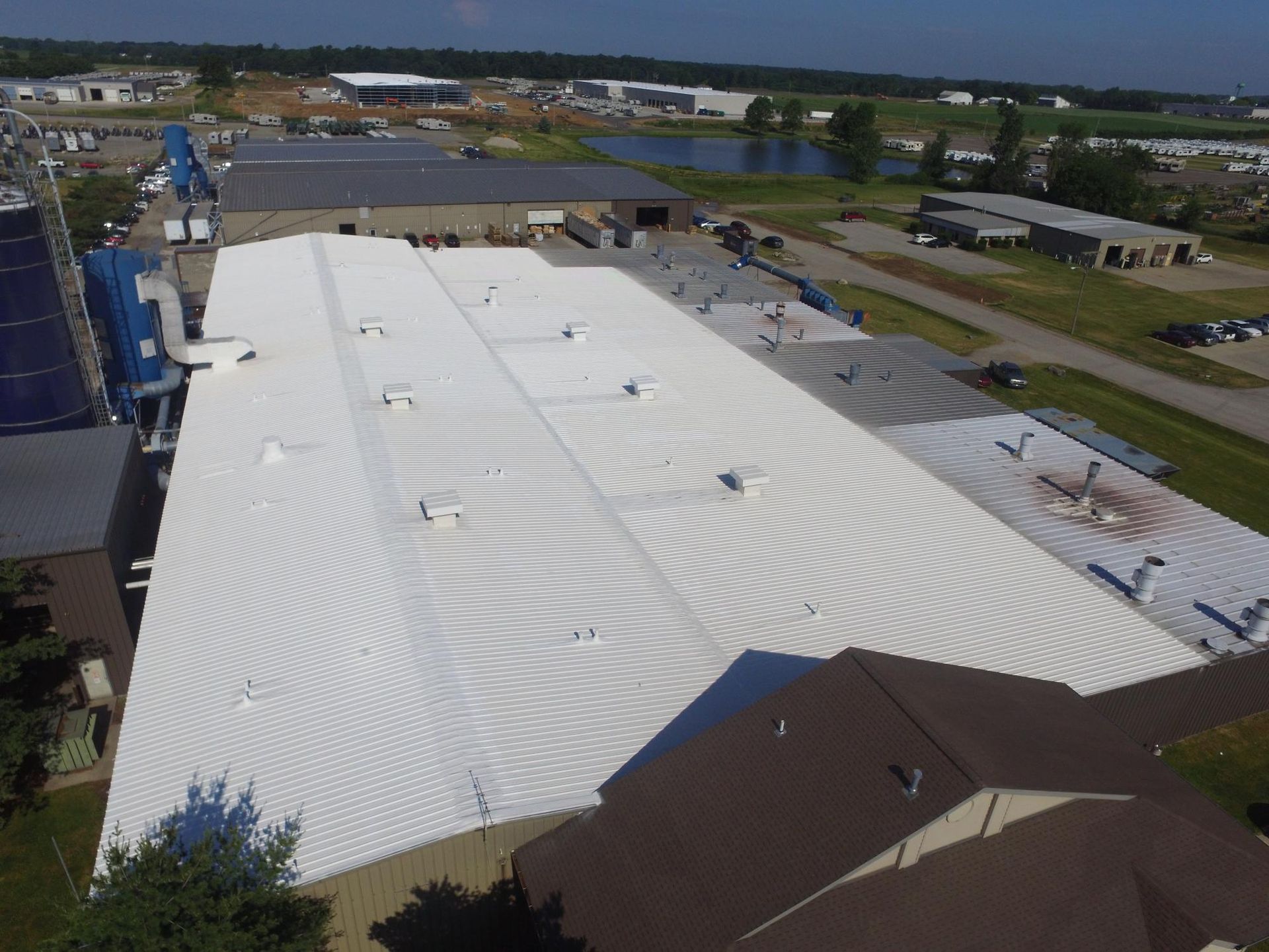 An aerial view of a large building with a white roof.