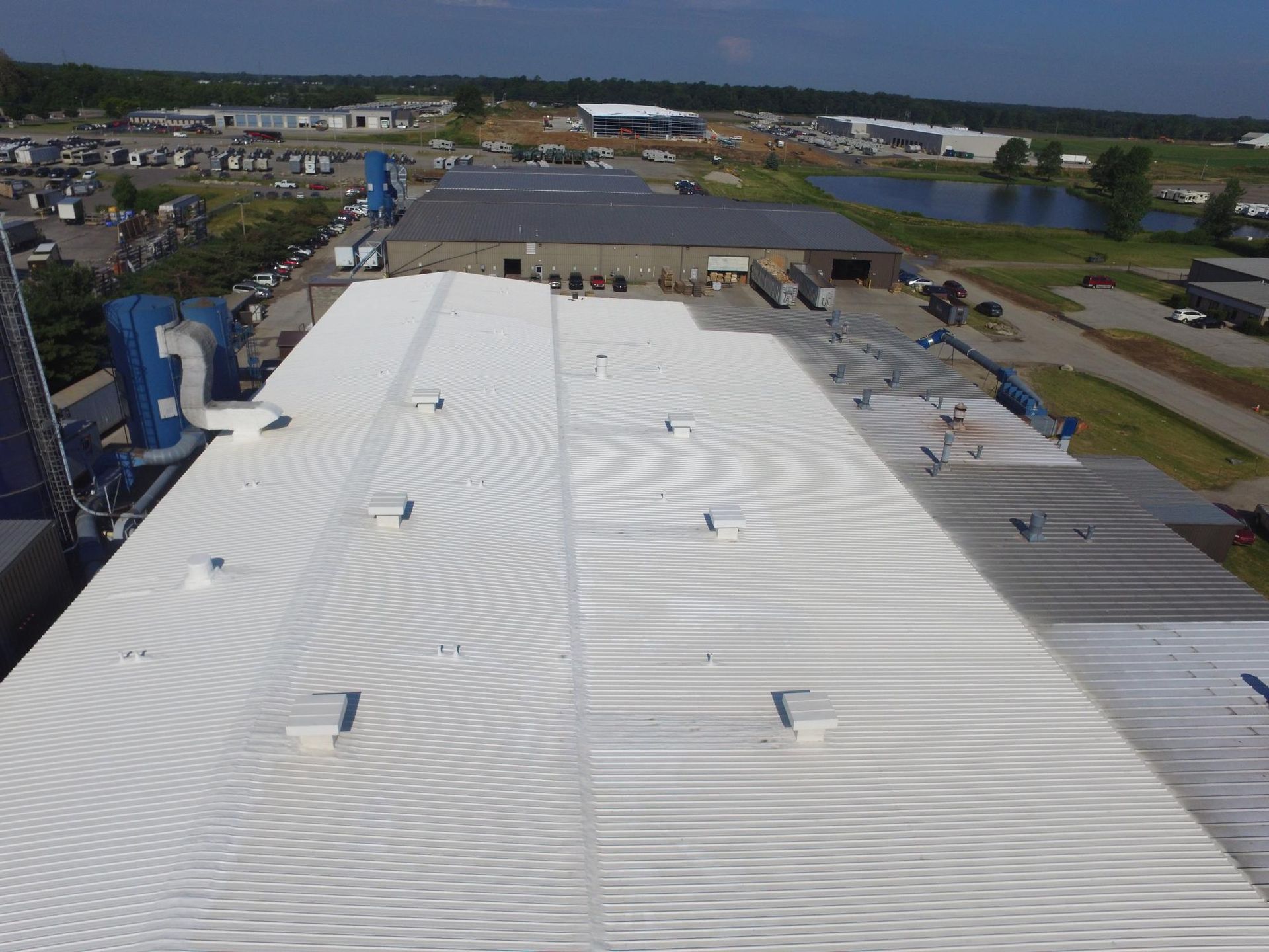 An aerial view of a large building with a white roof