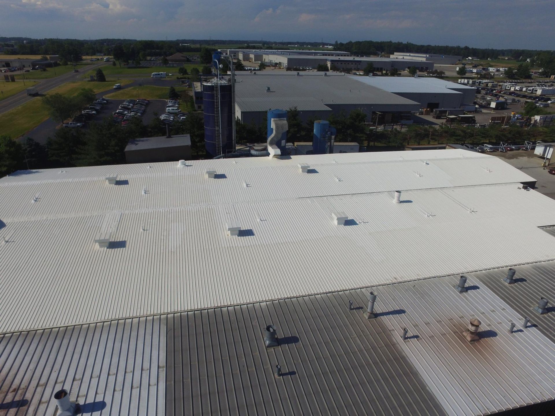 An aerial view of a large building with a white roof.