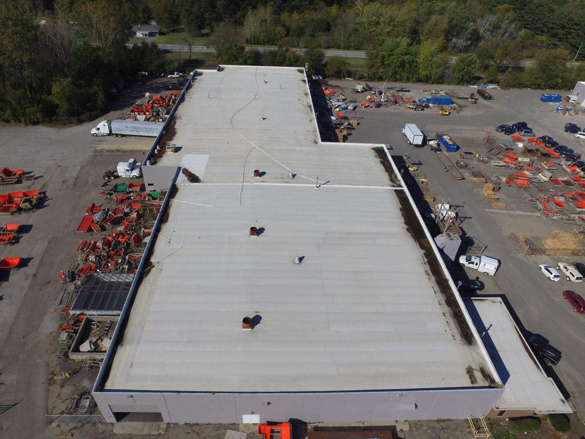 An aerial view of a large building with a white roof