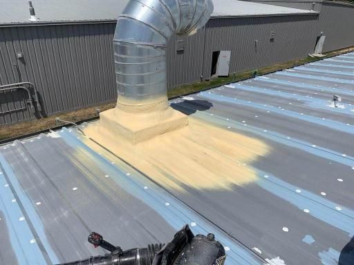 A man is painting the roof of a building.