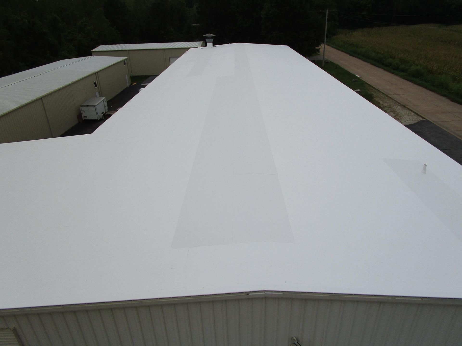 An aerial view of a large white building with a white roof.