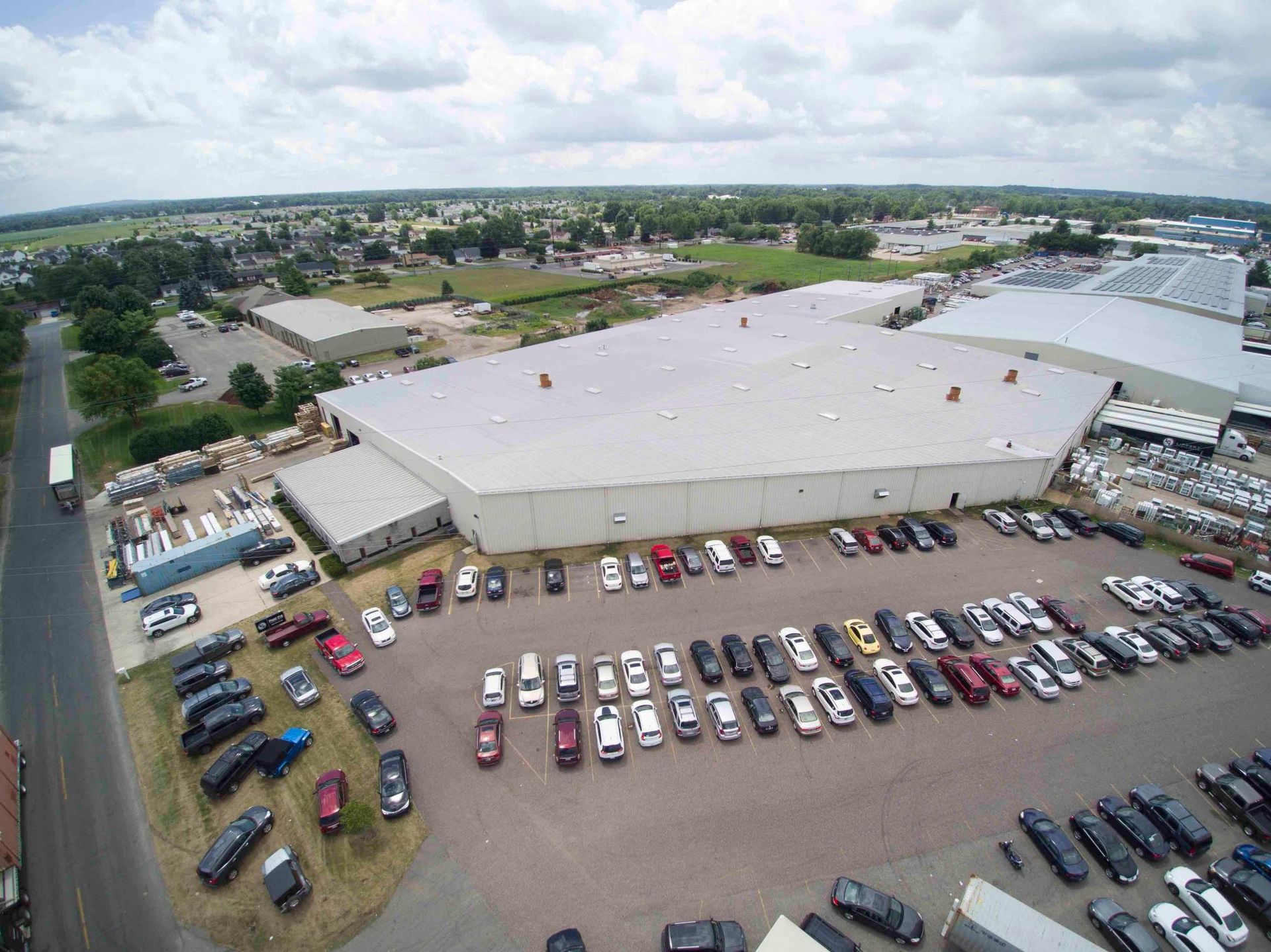 An aerial view of a large building with a lot of cars parked in front of it.