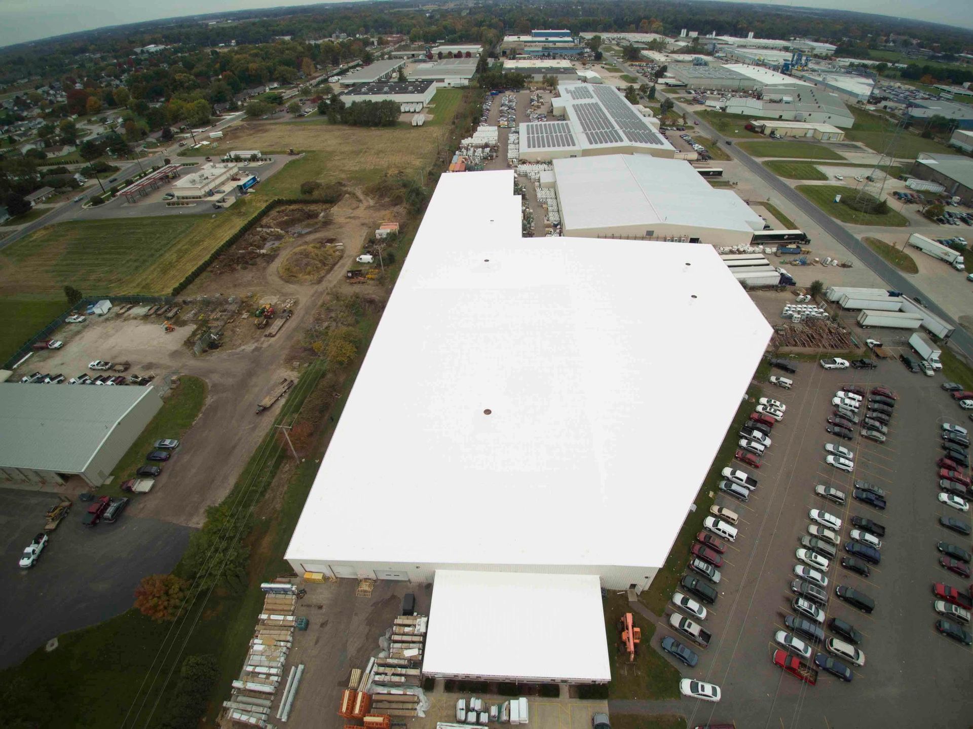 An aerial view of a large building with a white roof