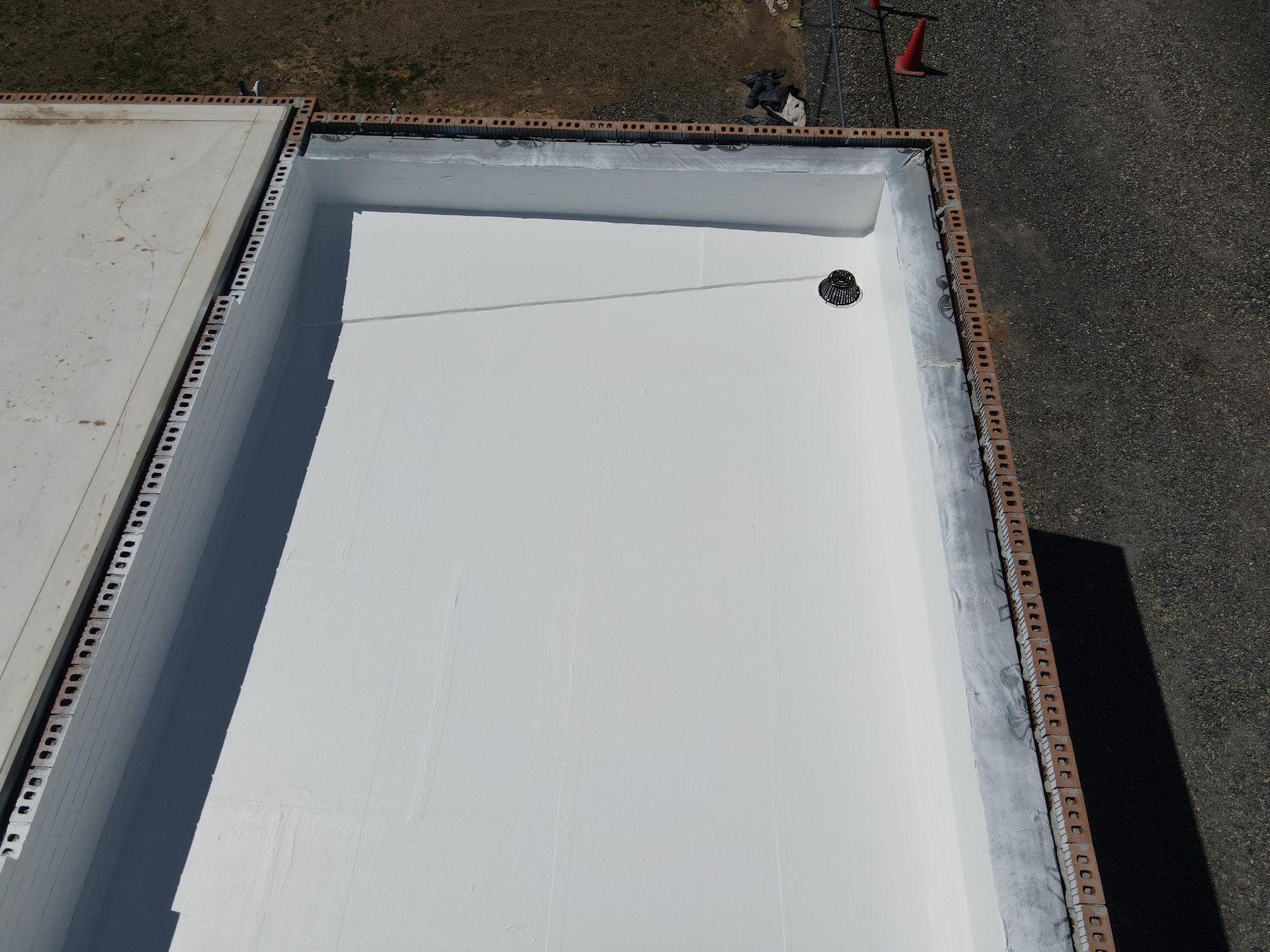 An aerial view of a white roof with a hole in it.