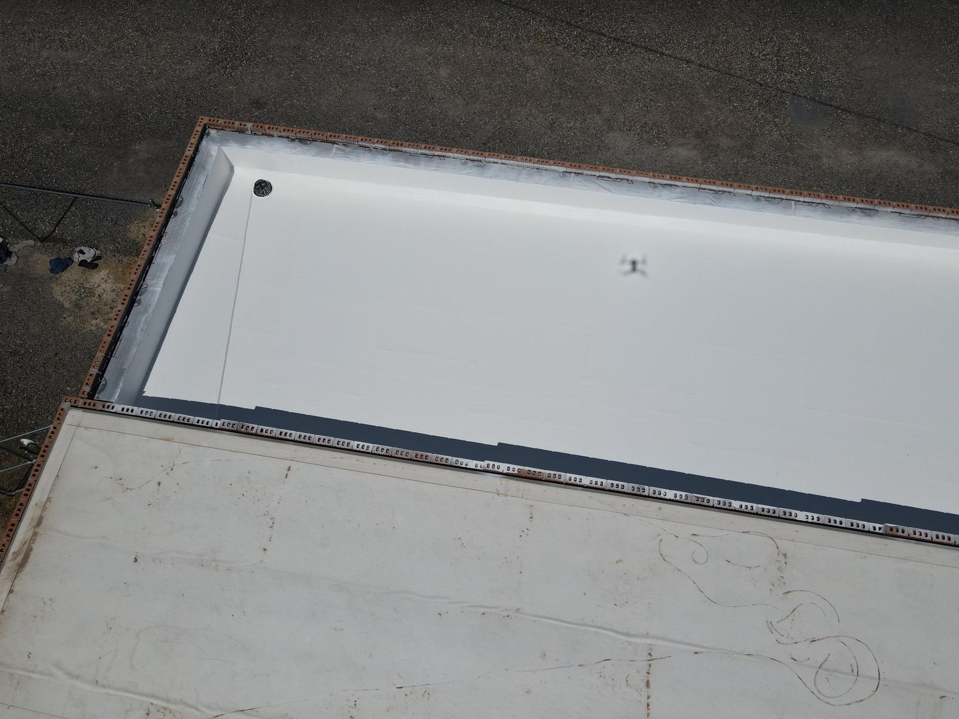 An aerial view of a white roof with a hole in it