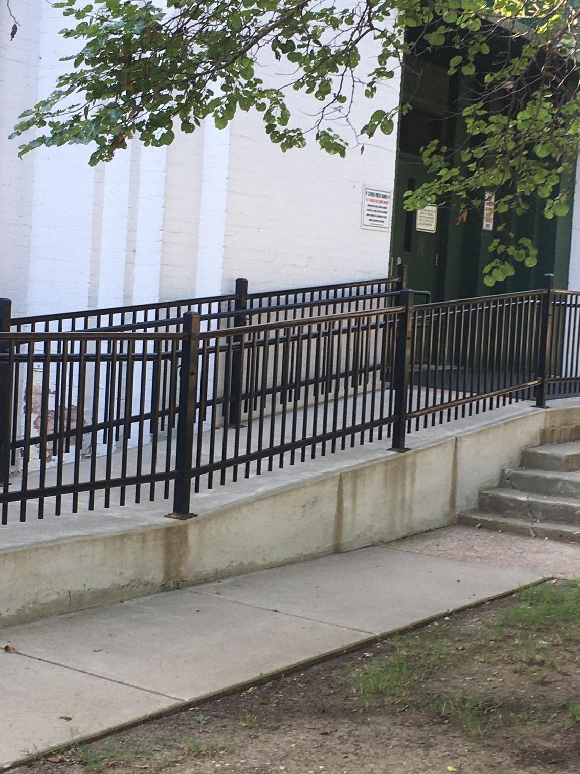A white building with a black fence around it