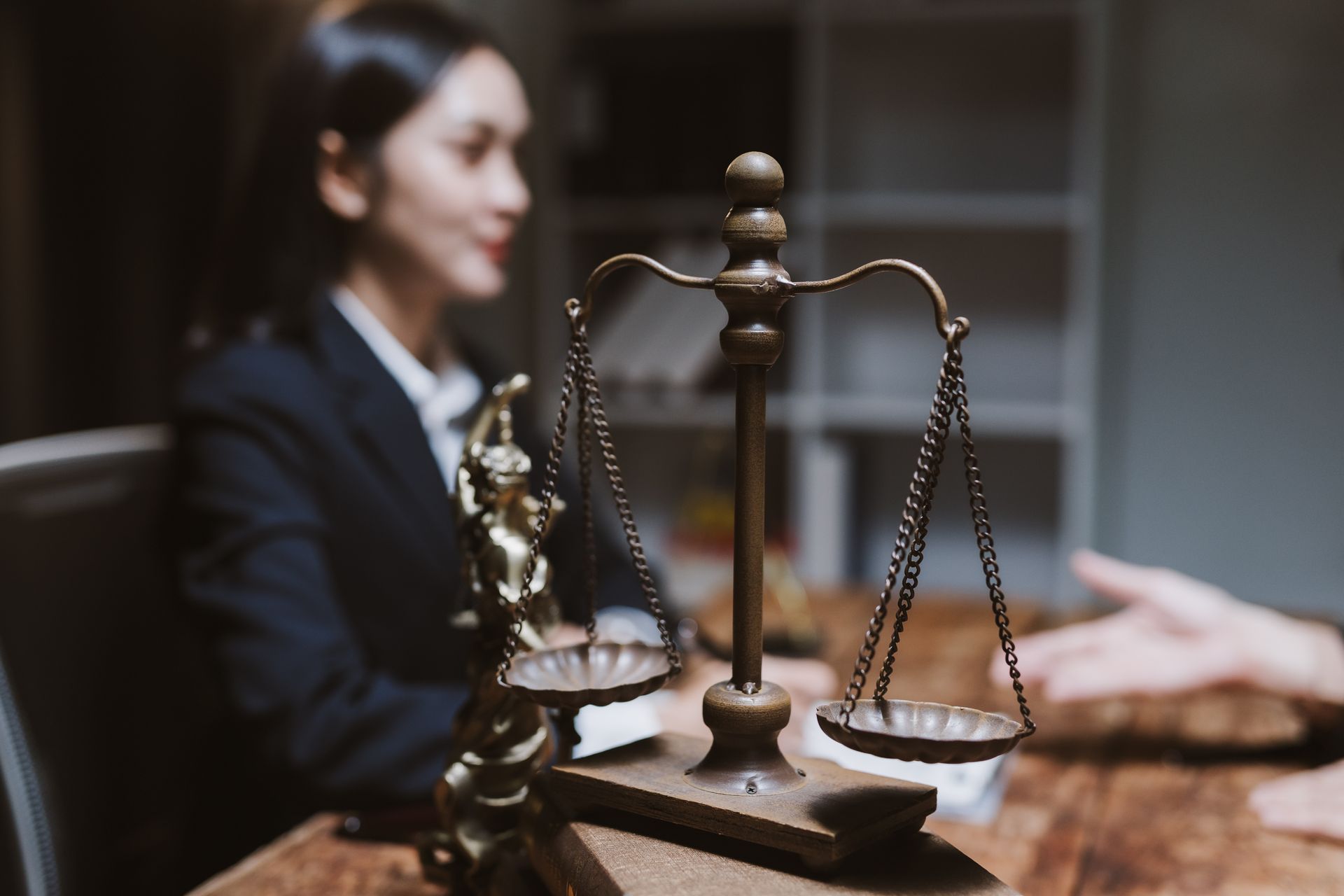 A professional criminal lawyer consulting with a client, featuring a vintage brass scale of justice. A professional criminal lawyer consulting with a client, featuring a vintage brass scale of justice.