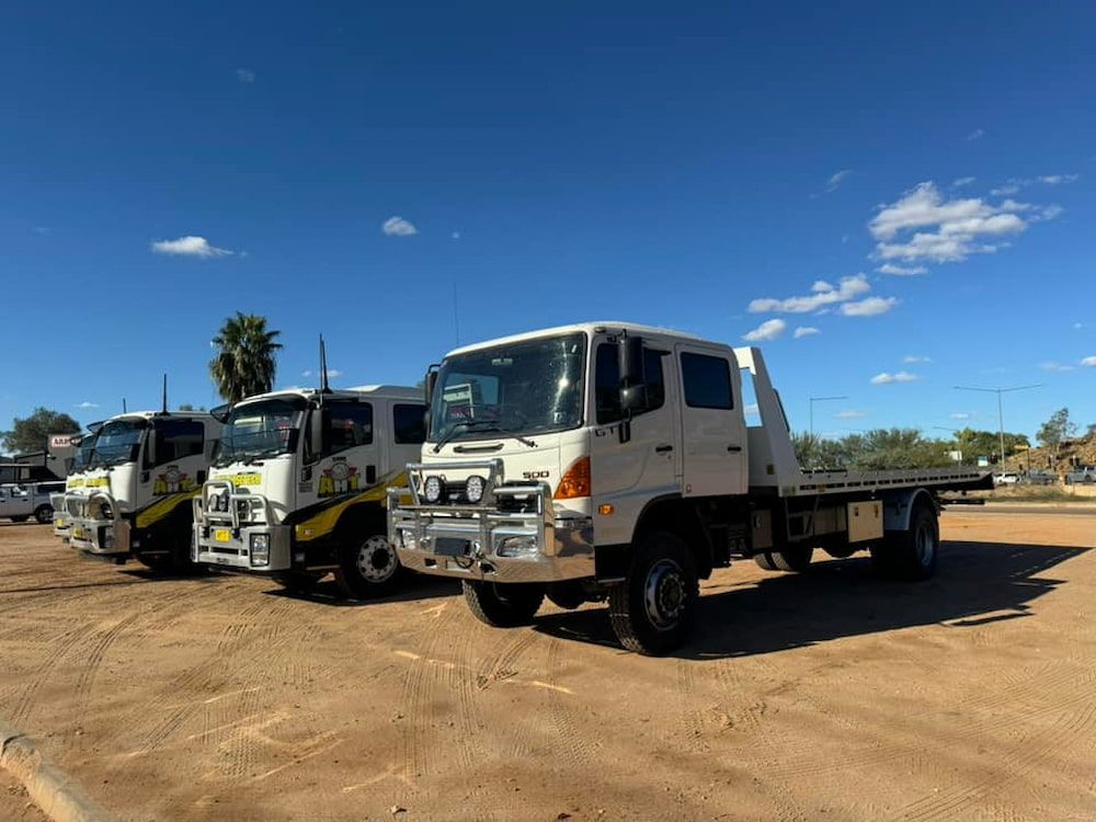 A Row Of Tow Trucks Are Parked In A Parking Lot — AHT Towing in Ciccone, NT
