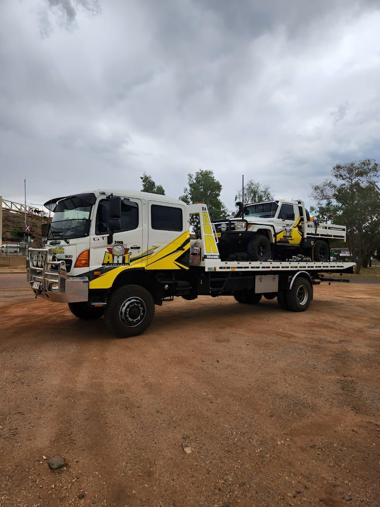 Two Tow Trucks Are Parked Next To Each Other On A Dirt Road — AHT Towing in Ciccone, NT