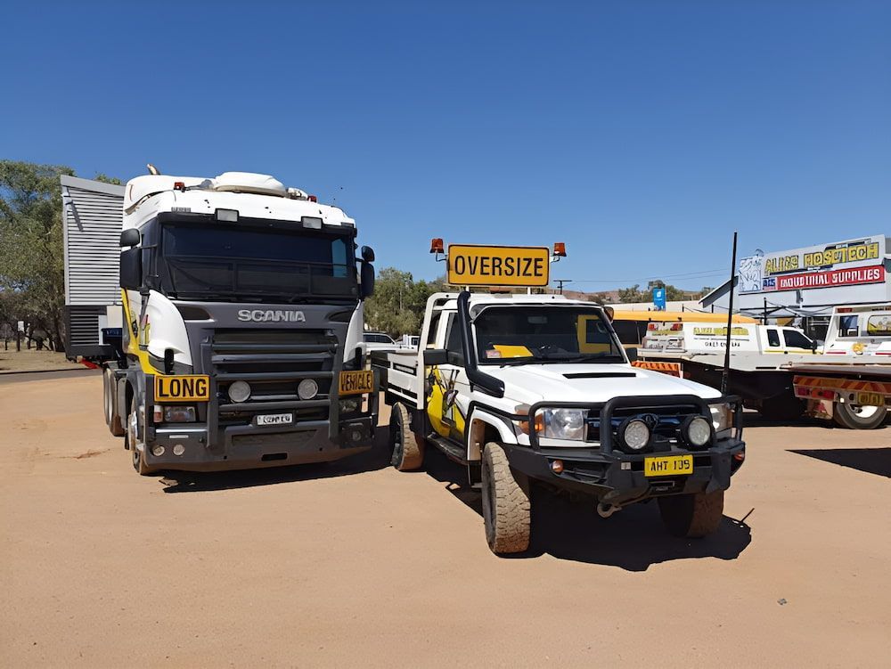 Two Trucks Are Parked Next To Each Other In A Dirt Lot — AHT Towing in Ciccone, NT