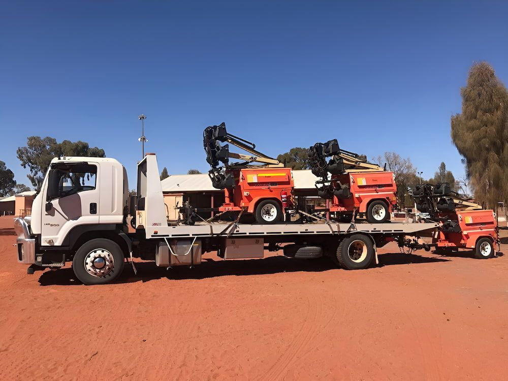 A Truck Is Carrying A Bunch Of Machinery On The Back Of It — AHT Towing in Ciccone, NT
