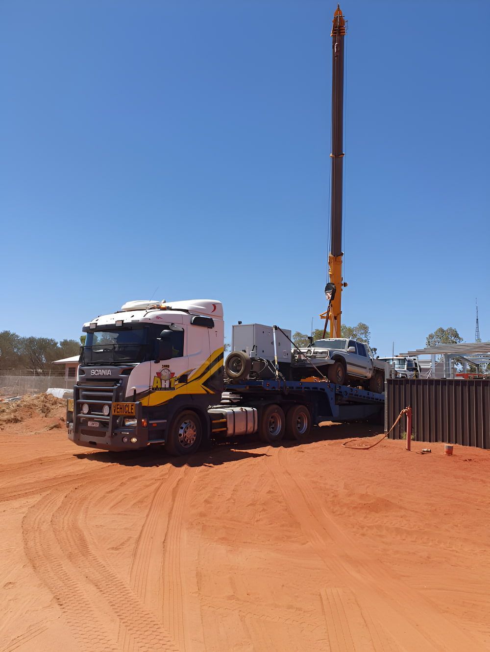 A Truck With A Crane On The Back Of It Is Parked In A Dirt Field — AHT Towing in Ciccone, NT