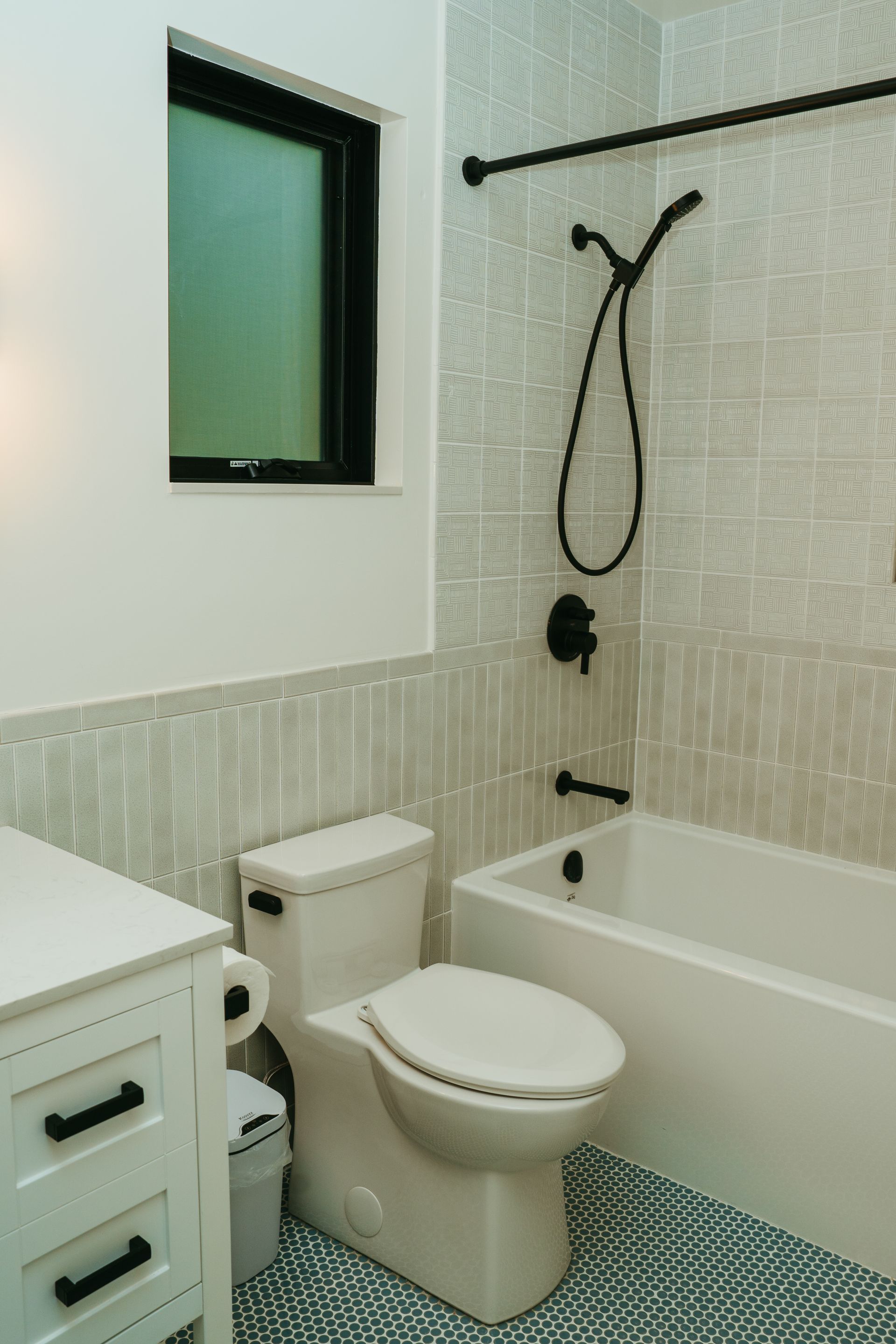A bathroom with a toilet , tub and shower.
