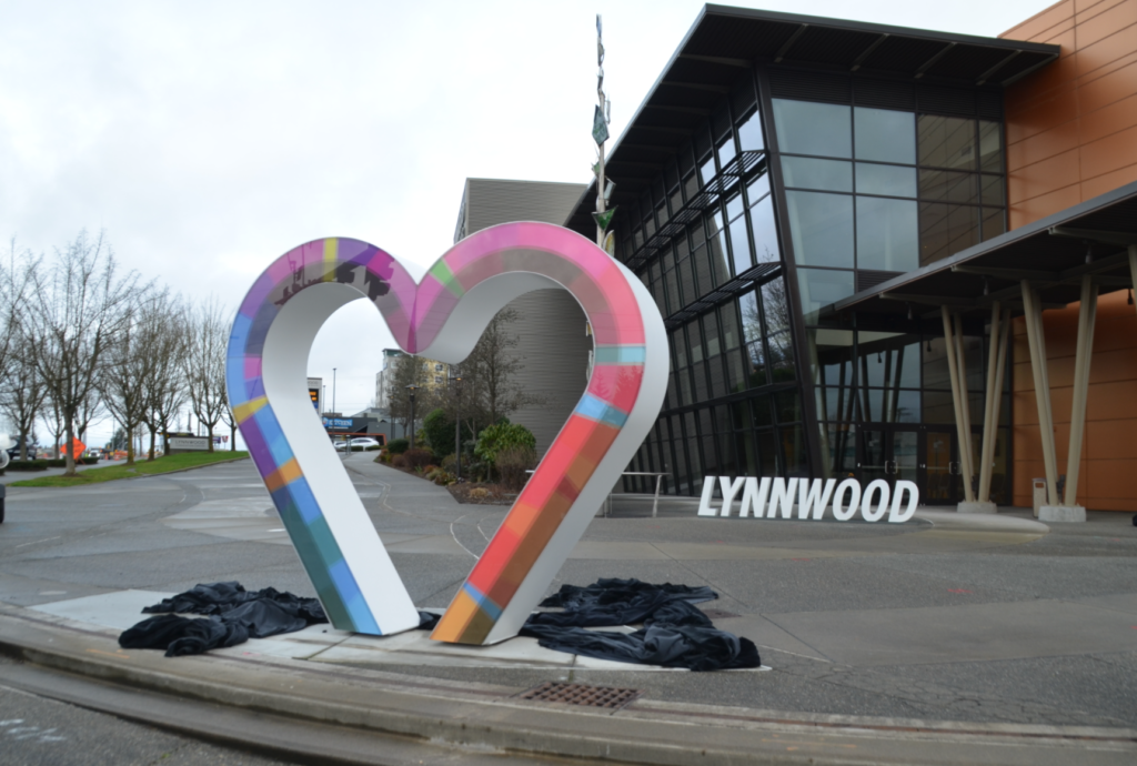 A large heart shaped sculpture in front of a building that says lynnwood