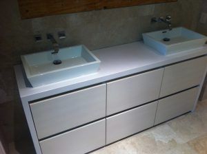 A bathroom vanity with two sinks and a mirror.