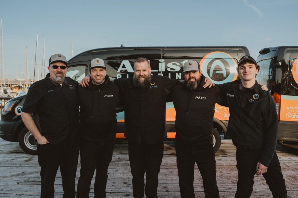 A group of A-List Plumbing Plumbers are posing for a picture in front of a van.