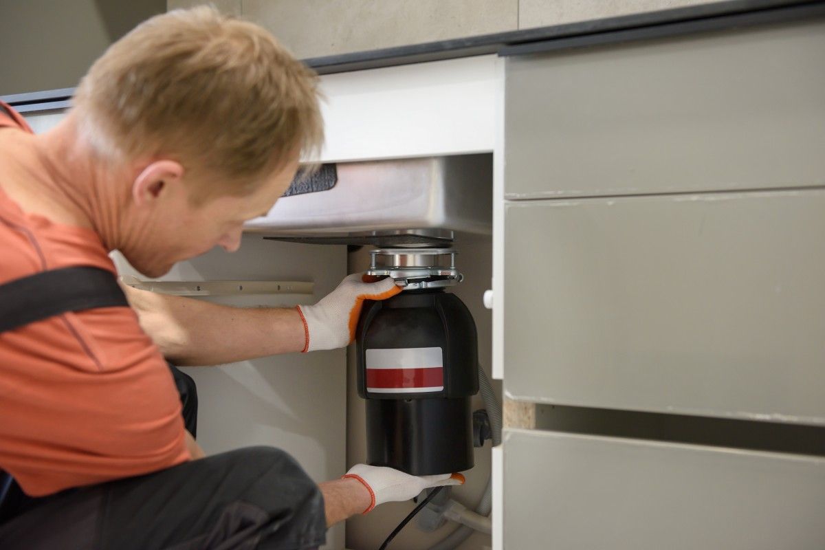 Plumber repairing garbage disposal