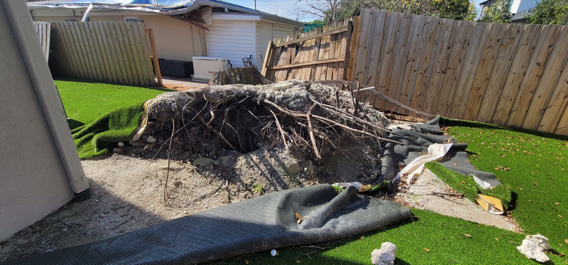 A pile of junk is sitting on top of a lush green lawn in a backyard.