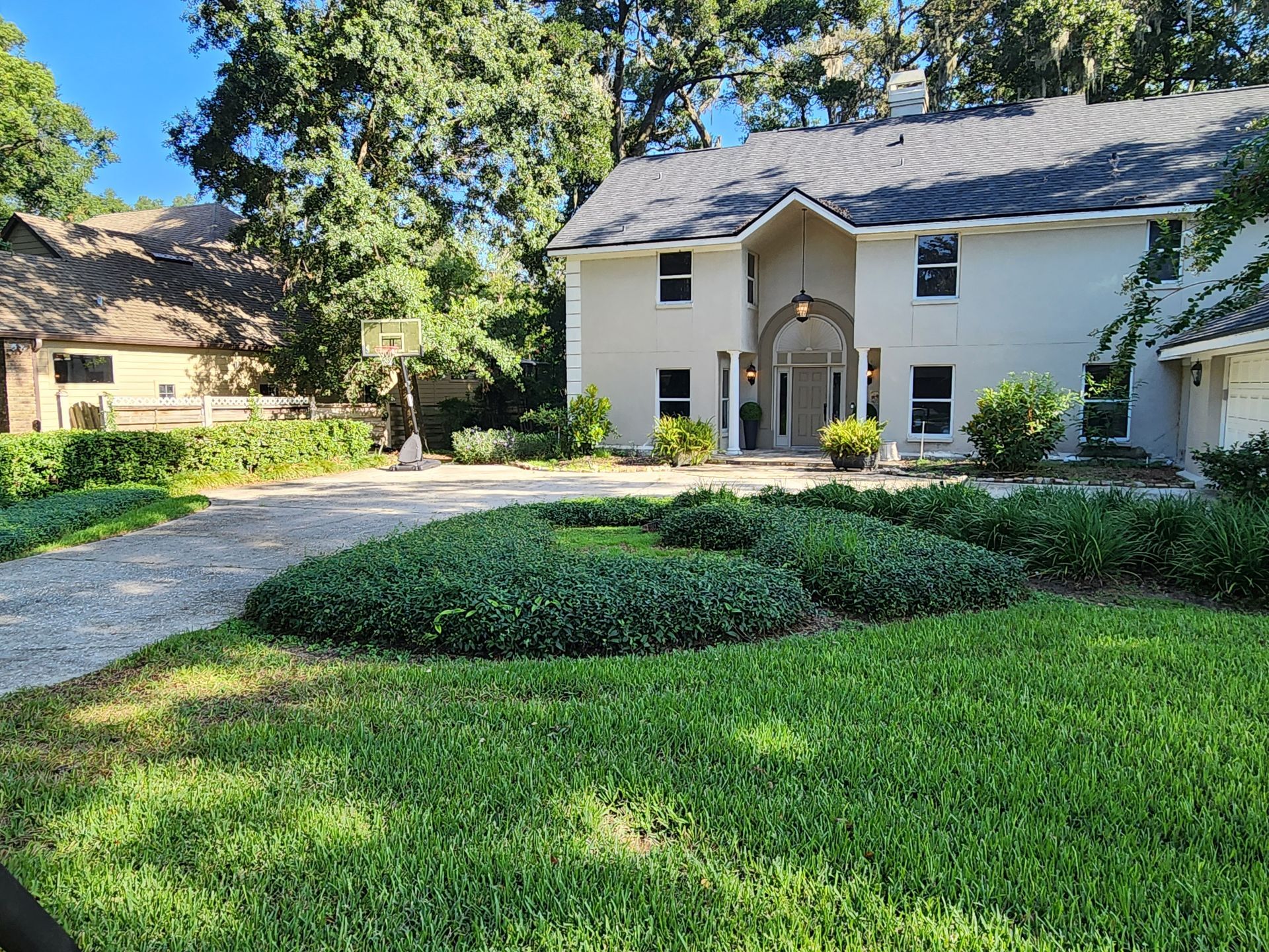 A large white house with a lush green lawn in front of it.