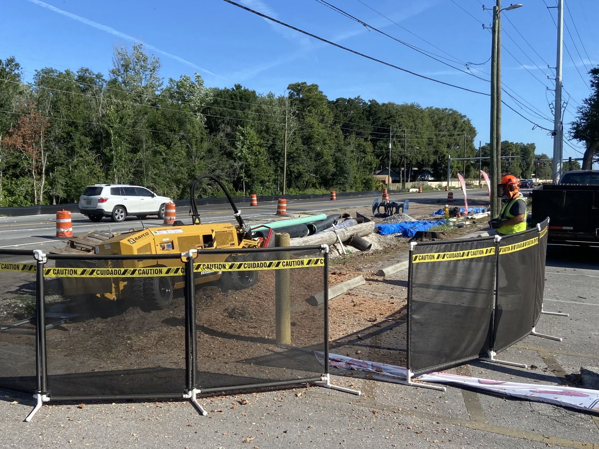 A construction site with a fence and a truck parked in the background.