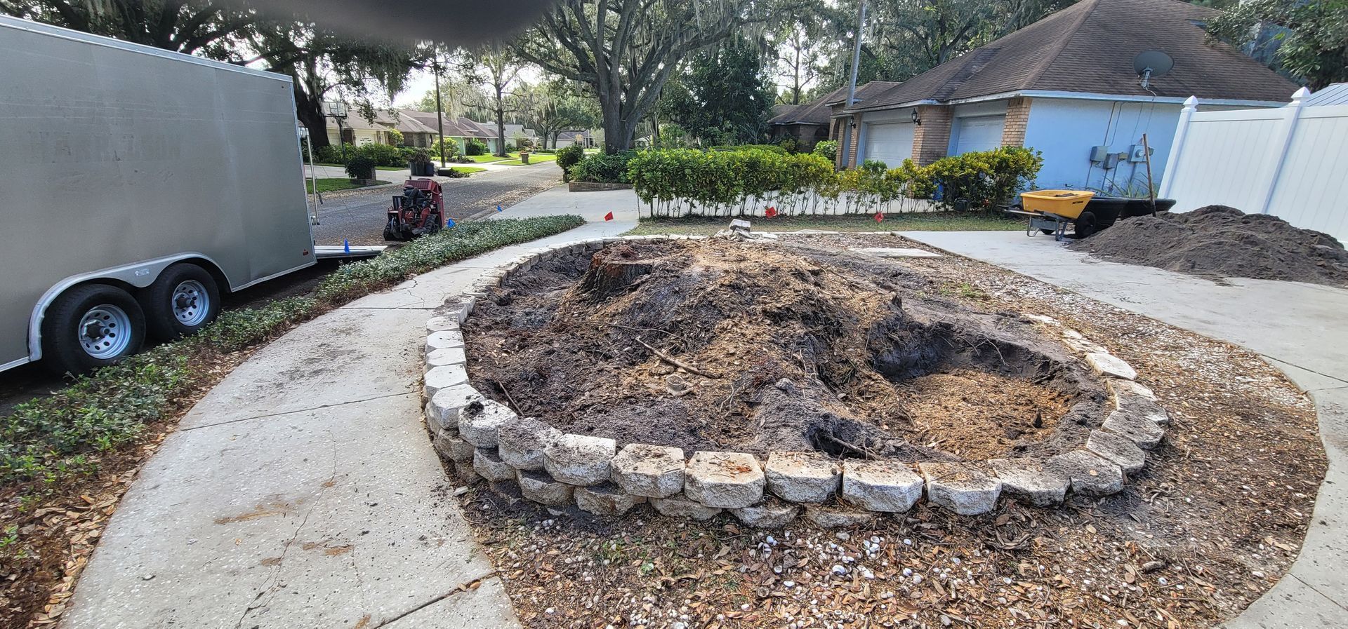 A fire pit is being built in a driveway in front of a house.