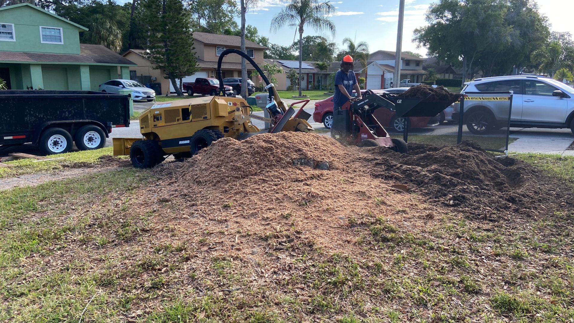 A man is using a machine to remove a tree stump.