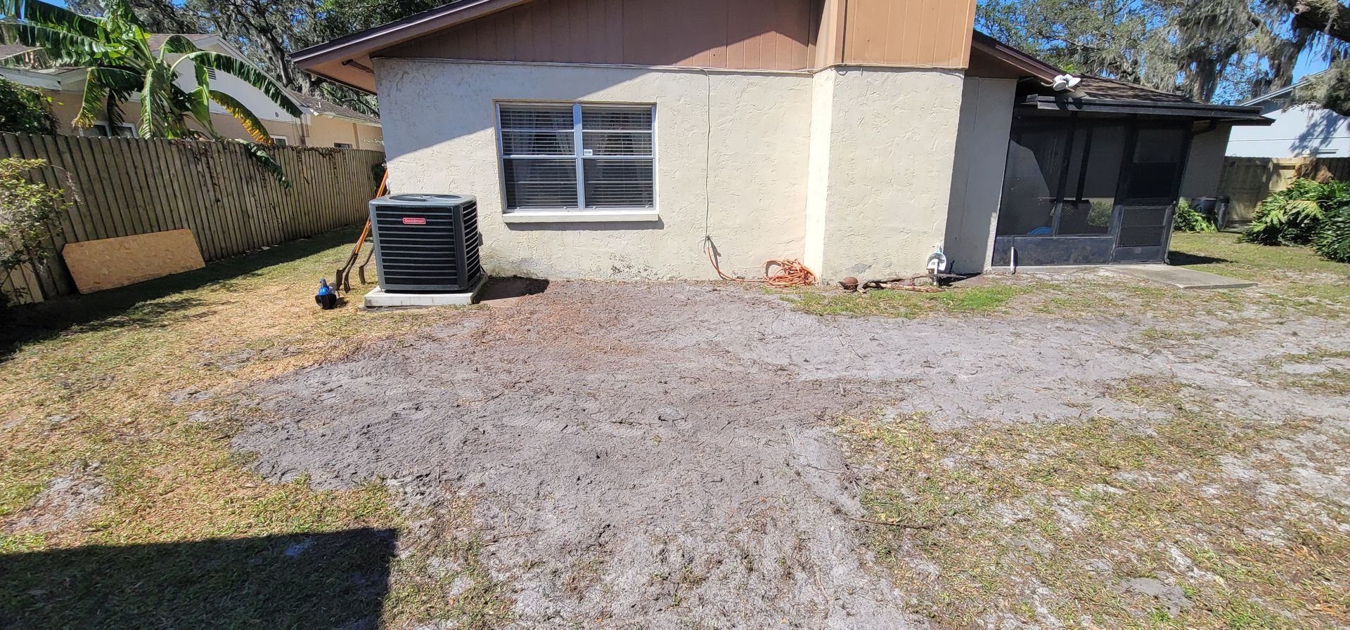 A small house with a gravel driveway in front of it.