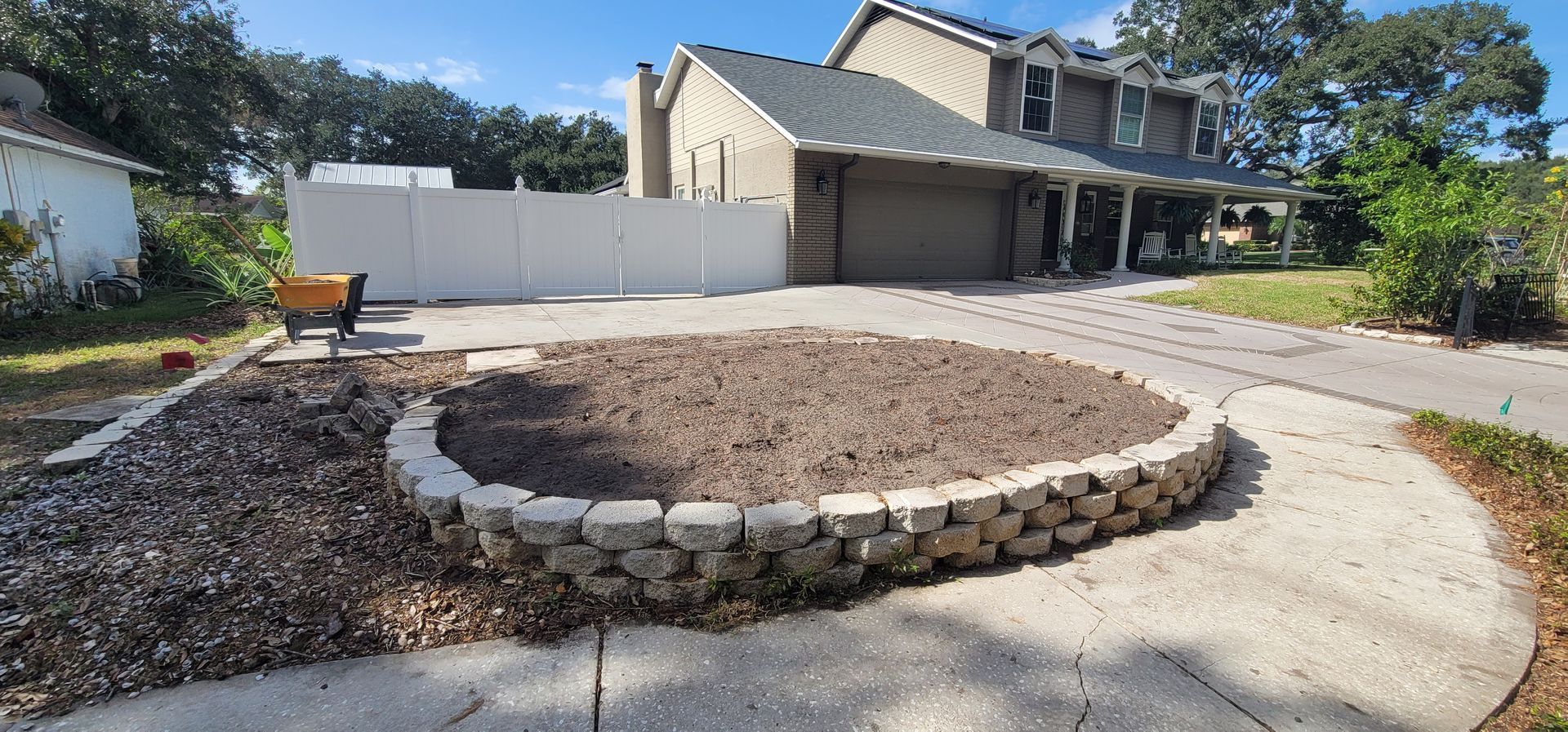 There is a fire pit in the middle of the driveway in front of a house.