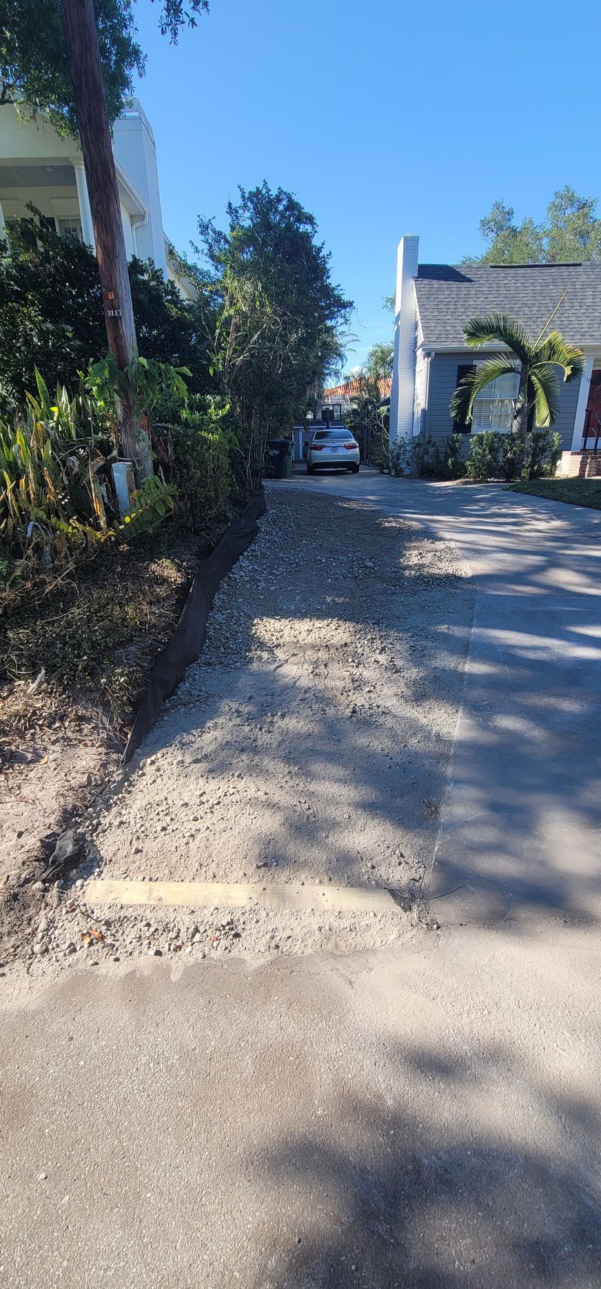 A car is parked in a driveway next to a house.