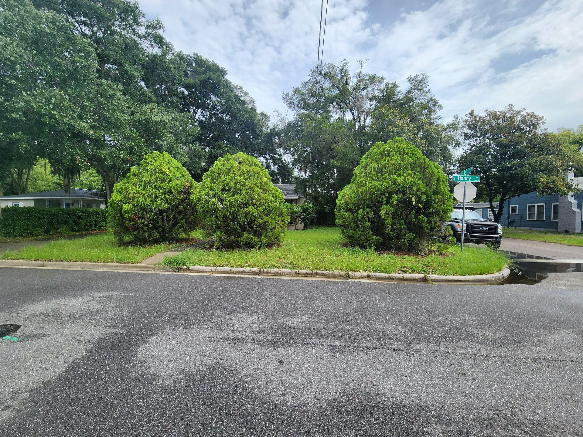 A car is parked on the side of the road in front of a house.