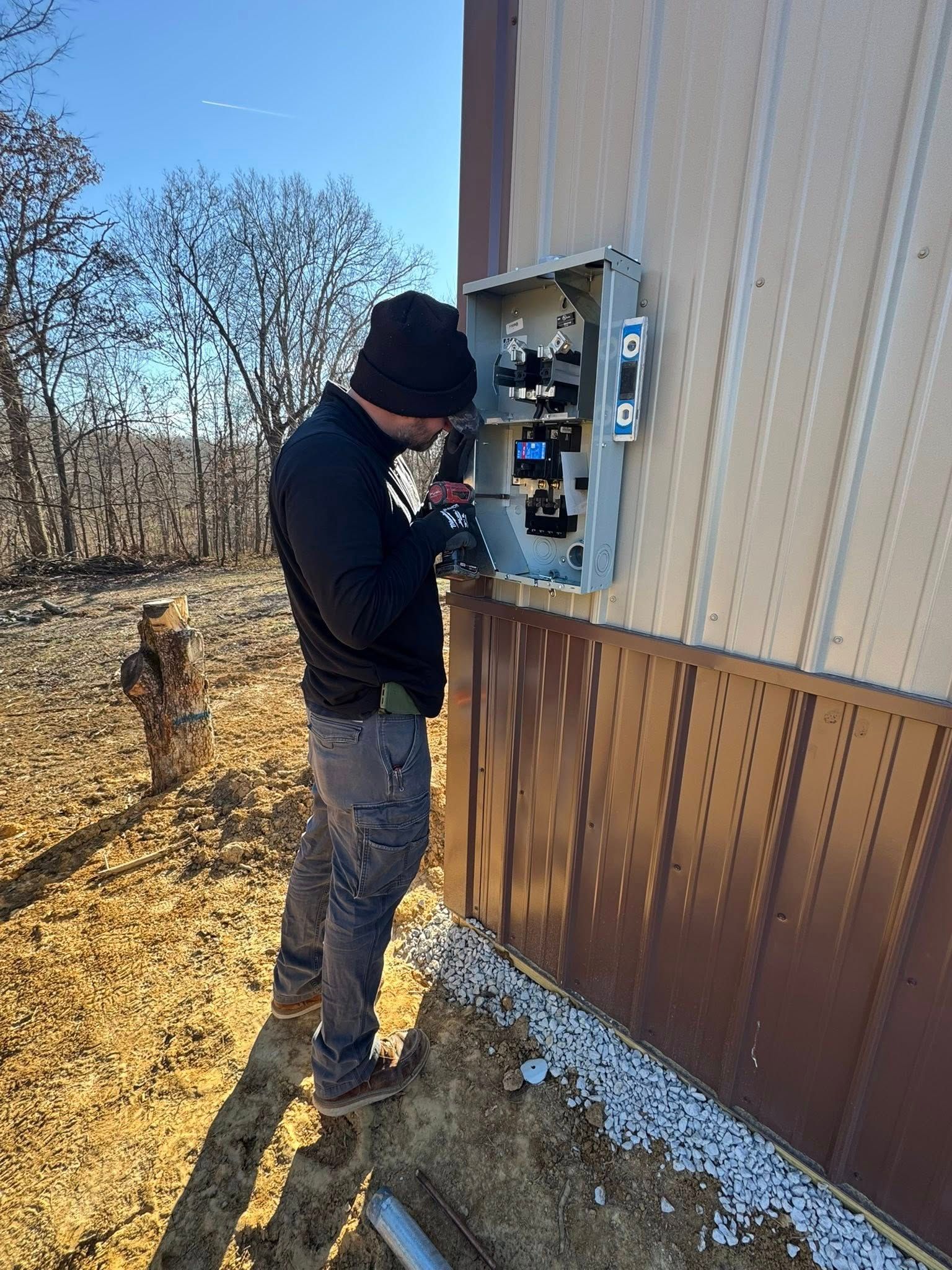 Woman in straw hat smiles, holding wine glass near a lake.