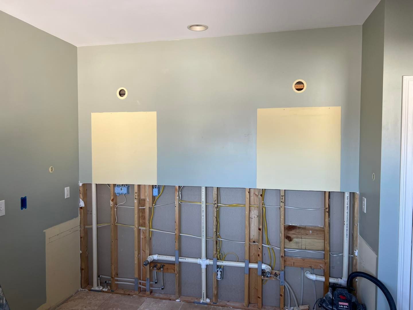 Woman in straw hat smiles, holding wine glass near a lake.
