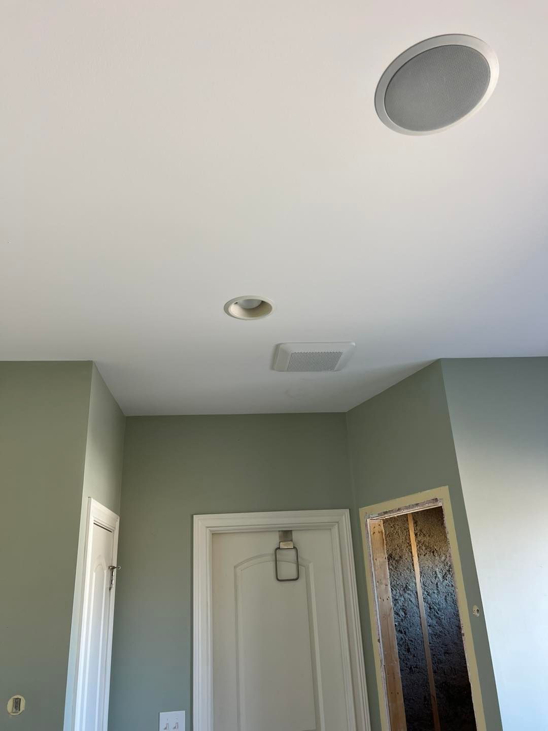Woman in straw hat smiles, holding wine glass near a lake.