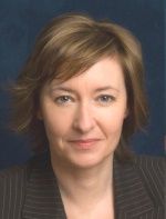 Man with glasses and dark suit, looking at the viewer.