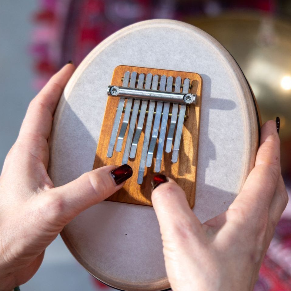 Een persoon bespeelt een kalimba, een houten duimpiano