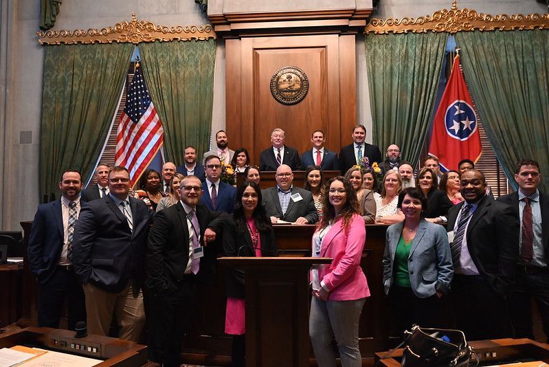 a woman in a blue jacket is leading a Leadership Oak Ridge class tour.